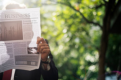 Businessman standing and reading newspaper